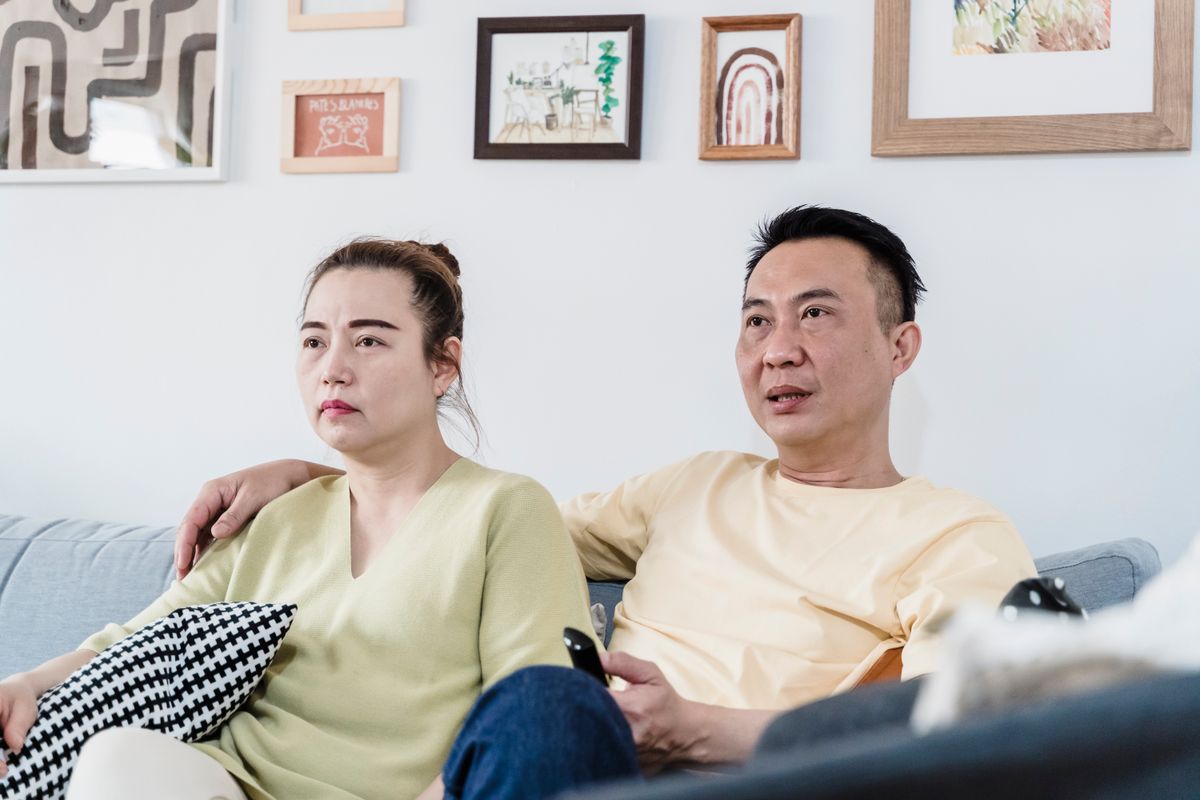 Casal sentado no sofá a uma distância confortável da televisão