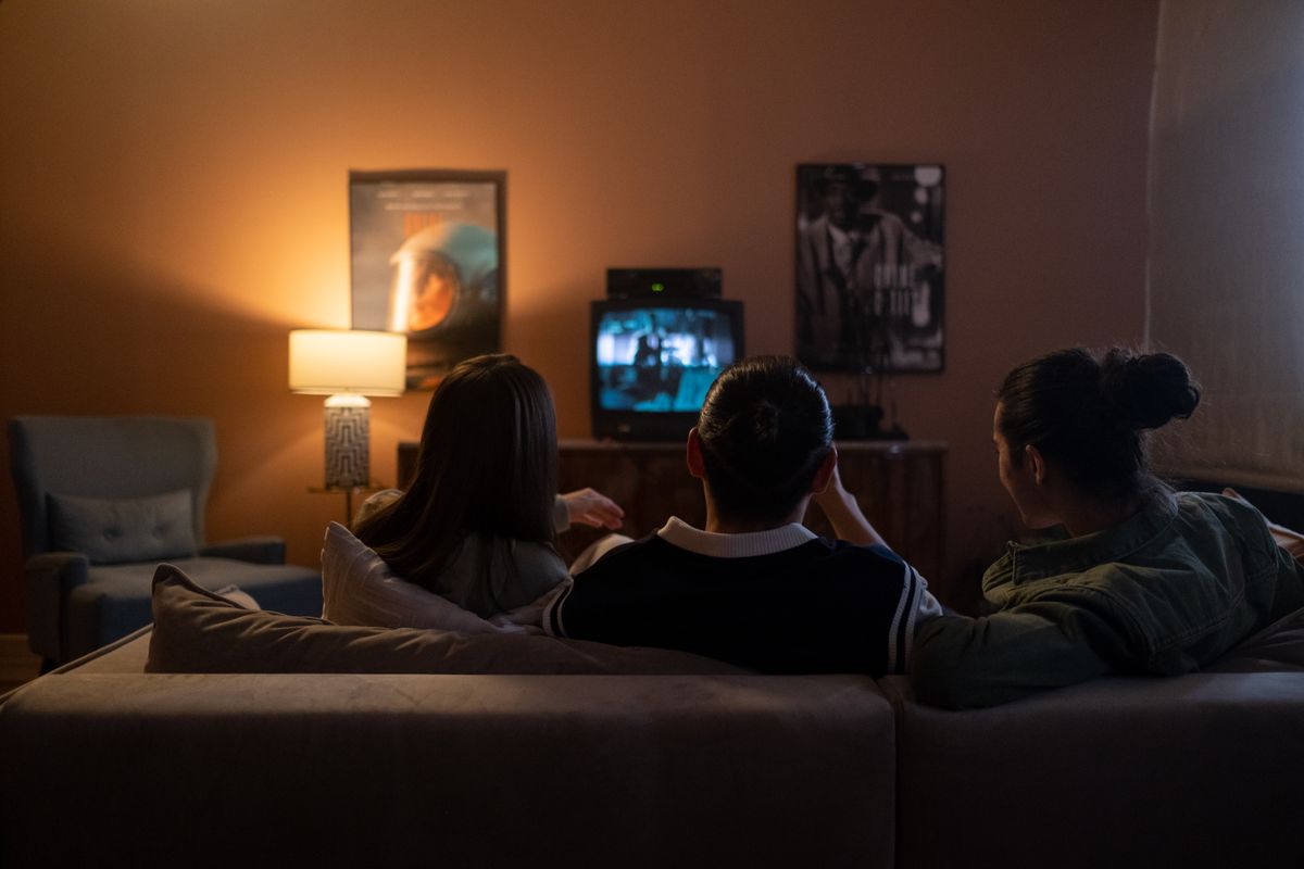 Amigos reunidos no sofá assistindo a um filme pela televisão